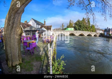 Fordingbridge, Hampshire, UK, 5. Januar 2024: Wetter: Strahlender Sonnenschein und blauer Himmel Freitag nach der Sintflut am Donnerstag im Süden Englands. Am George Inn, das direkt am Rande des Flusses Avon liegt, werden improvisierte Hochwasserschutzanlagen das Wasser am oberen Ende der Terrasse ablenken und das Gelände vor Überschwemmungsschäden schützen. Der Wasserstand könnte in den nächsten Tagen weiter steigen, da die Regenfälle von der Salisbury Plain flussaufwärts abfließen. Paul Biggins/Alamy Live News Stockfoto