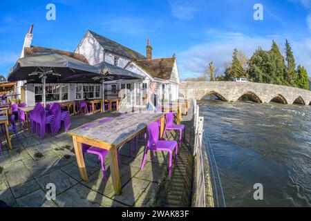 Fordingbridge, Hampshire, UK, 5. Januar 2024: Wetter: Strahlender Sonnenschein und blauer Himmel Freitag nach der Sintflut am Donnerstag im Süden Englands. Am George Inn, das direkt am Rande des Flusses Avon liegt, werden improvisierte Hochwasserschutzanlagen das Wasser am oberen Ende der Terrasse ablenken und das Gelände vor Überschwemmungsschäden schützen. Die Besitzerin Caroline Roylance untersucht den Tatort. Der Wasserstand könnte in den nächsten Tagen weiter steigen, da die Regenfälle von der Salisbury Plain flussaufwärts abfließen. Paul Biggins/Alamy Live News Stockfoto