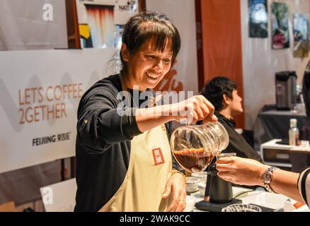 PU'er, chinesische Provinz Yunnan. Januar 2024. Ein Aussteller serviert Kaffee während der China (Pu'er) International Coffee Expo in Pu'er, südwestchinesische Provinz Yunnan, 5. Januar 2024. Mehr als 200 Unternehmen nahmen vom 5. Bis 7. Januar an der China (Pu'er) International Coffee Expo Teil. Quelle: Xiong Xuanang/Xinhua/Alamy Live News Stockfoto