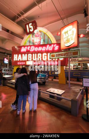 Mädchen machen Selfie vor dem alten McDonald's Schild und 1956 Chevrolet Bel Air im Henry Ford Museum of American Innovation Stockfoto