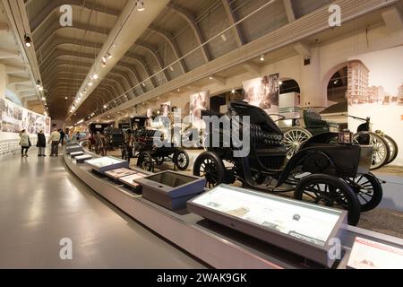 Antike Autos bei der Driving America Exhibit im Henry Ford Museum of American Innovation. Davor befindet sich der 1901 Columbia Victoria Elektrowagen. Stockfoto