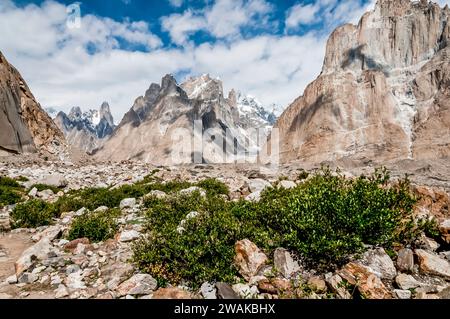 Pakistan, nördliche Gebiete der Karakorum Mountains. Bildbild mit Blick über den mit Schutt übersäten Baltoro-Gletscher, in Richtung des Uli Biaho-Turms auf der linken Seite, des Großraums Trango in der Mitte und der Cathedral Peaks auf der rechten Seite. Stockfoto