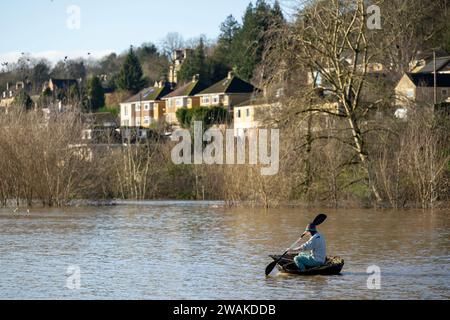 Scharlach Henderson nimmt das Hochwasser in ihrem Haus gebauten Korakel auf, wo der Fluss Avon bei Batheaston nach Sturm Henk seine Ufer geplatzt hat. Stockfoto