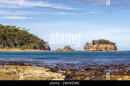 Der tessellierte Pflaster am Pirates Bay Beach, Tasmanien, mit Blick auf Clyde's Island. Sommerblick mit blauem Himmel. Stockfoto