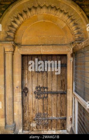 Großbritannien, England, Oxfordshire, Fringford, Main Street, St. Michal und alle Engel Kirche alte Tür mit dekorativem alten Eisenscharnier Stockfoto