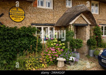 Großbritannien, England, Oxfordshire, Fringford, Main Street, AA-Dorfschild und Tür des alten Postamtes, wo Flora Thompson arbeitete Stockfoto