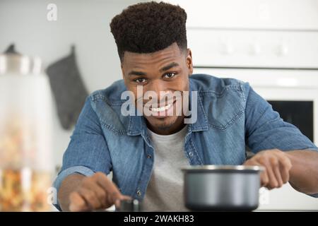 Hübscher junger Mann, der zu Hause in der Küche Pasta kocht Stockfoto