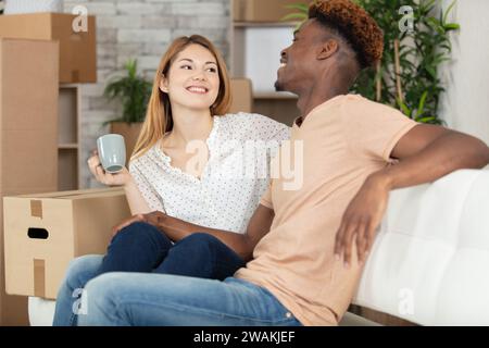 Glückliches Paar, das am Umzugstag eine Pause macht Stockfoto