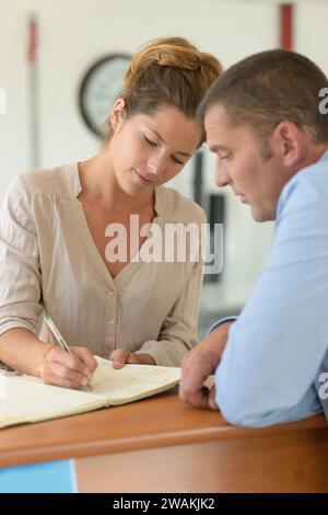 Das Paar unterschreibt ein Buch Stockfoto