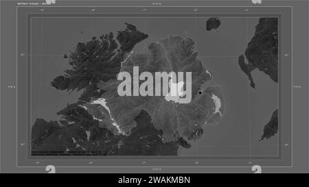 Nordirland wird auf einer grauen Höhenkarte mit Seen- und Flusskarte mit Landeshauptstadt, kartographischem Raster und Entfernungsskala hervorgehoben Stockfoto
