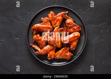 Gegrillte Hähnchenflügel auf Teller. Draufsicht, flach Stockfoto