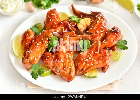 Klebrige Honig-Soja-Hähnchenflügel mit weißem Sesam auf Teller Stockfoto