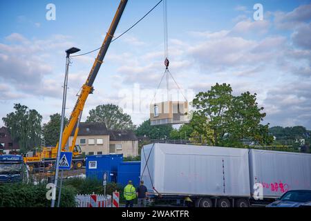 In Essen baut der Bauverein Kettwig in Ickten neu. Die Bauweise besteht aus Fertigbauteilen. Tieflader bringen Fertigbauteile zu einer Bause Stockfoto