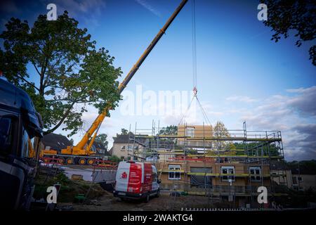 In Essen baut der Bauverein Kettwig in Ickten neu. Die Bauweise besteht aus Fertigbauteilen. Ein Fertigbauteil wird mit einem Kran eingehobe Stockfoto