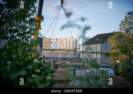 In Essen baut der Bauverein Kettwig in Ickten neu. Die Bauweise besteht aus Fertigbauteilen. Ein Fertigbauteil wird mit einem Kran eingehobe Stockfoto