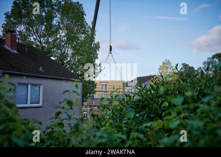 In Essen baut der Bauverein Kettwig in Ickten neu. Die Bauweise besteht aus Fertigbauteilen. Ein Fertigbauteil wird mit einem Kran eingehobe Stockfoto