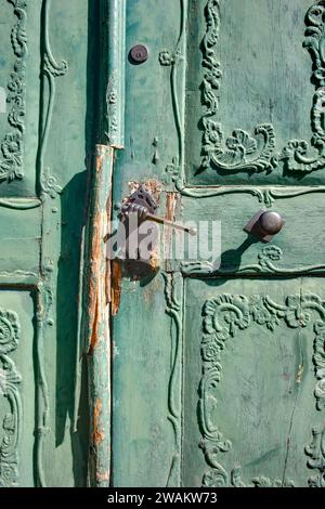 Alte grüne Holztür, Türgriff mit Trommelstab in der Hand, Blankenburg, Sachsen-Anhalt, Deutschland, Europa Stockfoto