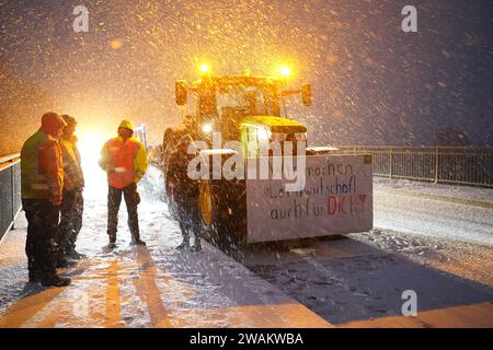 05. Januar 2024, Schleswig-Holstein, Kölln-Reisiek: Bauern protestieren mit ihren Traktoren und Plakaten auf einer Brücke über die Autobahn A23. Als Reaktion auf die Sparpläne der Bundesregierung hat der Bauernverband eine Aktionswoche mit Kundgebungen und Kundgebungen ab dem 8. Januar gefordert. Am 15. Januar wird es in einer großen Demonstration in der Hauptstadt enden. Foto: Marcus Brandt/dpa Stockfoto