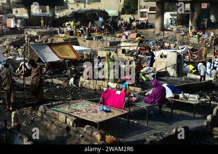 Ansicht des Ortes nach einem Feuerausbruch in einem Slum aus unbekannten Gründen, während die Bewohner am Freitag, den 5. Januar 2024 ihre provisorischen Häuser in der Gegend von Teen Hatti in Karachi restaurierten. Ein riesiges Feuer zerstörte am Donnerstagabend rund 60 Hütten unter der Teen Hatti Brücke, sagten Polizei- und Rettungsdienste. Niemand wurde bei dem Vorfall verletzt. Stockfoto