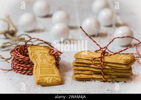 Speculoos Kekse mit rotem Band auf weißem Hintergrund mit Weihnachtsdekoration. Europäische Spezialität zu Weihnachten. Stockfoto