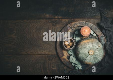 Holzteller mit Kürbis und Kerzen zur Dekoration auf hölzernem Hintergrund, Draufsicht mit Kopierraum Stockfoto