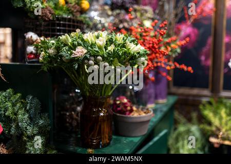 In der Nähe des Blumenladens gibt es eine Vielzahl von Farben. Grosse Sträuße in Zinnvasen. Stockfoto