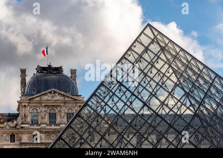 Außenansicht des Sully Pavillons des Louvre-Palastes und des Museums mit der berühmten Glaspyramide im Vordergrund Stockfoto