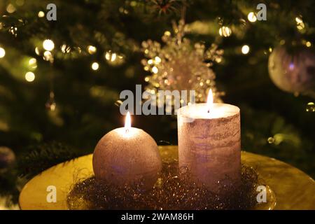 Nahaufnahme brennender Kerzen auf einem goldenen Teller, weihnachtlicher Hintergrund, Seitenansicht, Kopierraum Stockfoto