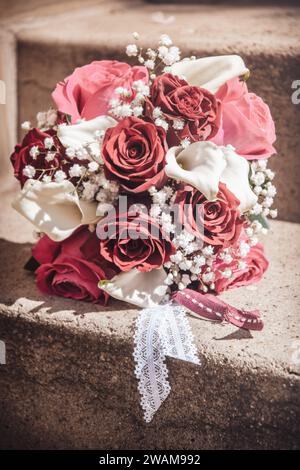 Brautstrauß mit roten, rosa und weißen Rosen, weißen Callas und gypsophila, vertikal Stockfoto