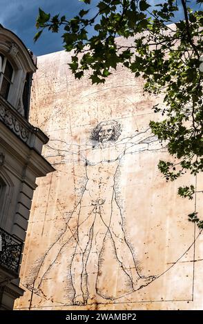 Riesige Reproduktion von Leonardo da Vincis Zeichnung des Vitruvianischen Mannes an der Wand eines Gebäudes an der Champs Elysees, Paris Stockfoto