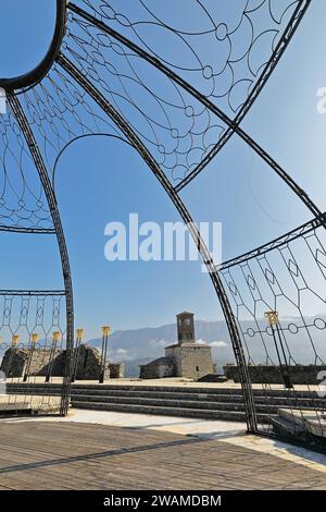 207+ Uhrenturm, eingerahmt von der Struktur der Outdoor-Bühne, die das National Folk Festival, Lunxheri im Hintergrund abhält. Gjirokaster-Albanien. Stockfoto