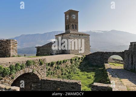 208+ Uhrenturm und nahe gelegene Gebäude, Durchgänge und Bögen an der Spitze der Festung, Lunxheri im Hintergrund. Gjirokaster-Albanien. Stockfoto