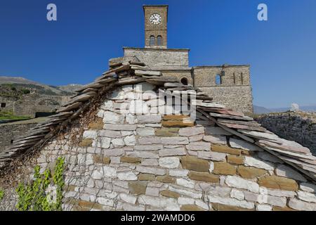 211 Uhr Turm und nahe gelegene Gebäudedächer und Bögen an der Spitze der Festung, im Hintergrund des Berges Mali i i Gjere. Gjirokaster-Albanien. Stockfoto