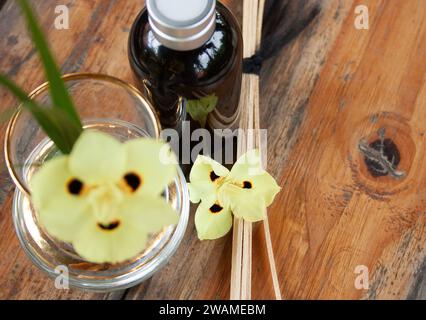 Nahaufnahme der gelben Blume mit duftender Diffusorflasche. Spa-Konzept. Szenenfoto Stockfoto