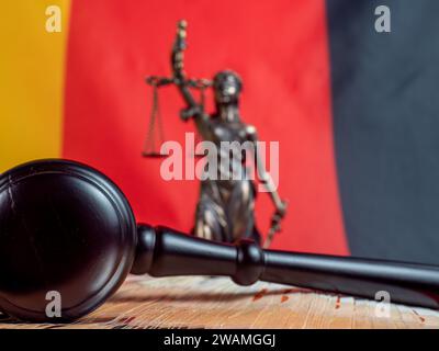 Der Hammer des Richters liegt auf 50-Euro-Scheinen vor dem Hintergrund der deutschen Flagge. Recht und Gerechtigkeit. Stockfoto