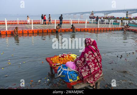 Ayodhya, Indien. Dezember 2023. Eine Frau verkauft Blumen am Ufer des Sarayu Flusses. Die antike Stadt Ayodhya liegt am Ufer des Flusses Sarayu und ist der Geburtsort von Lord RAM und gilt als sehr religiös. (Foto: Biplov Bhuyan/SOPA Images/SIPA USA) Credit: SIPA USA/Alamy Live News Stockfoto