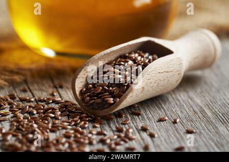 Leinsamen auf einem Löffel mit Leinsamenöl in einer Flasche Stockfoto