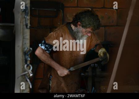 Auckland, Neuseeland. Ein einheimischer Schmied, der in seiner Werkstatt auf einem Bauernmarkt arbeitet Stockfoto