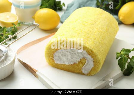 Leckere Kuchenbrötchen, Minze, Zitronen und Puderzucker auf weißem Tisch, Nahaufnahme Stockfoto