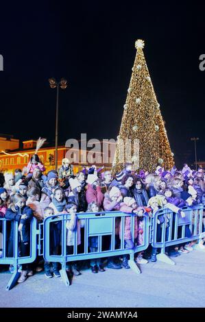 Latina, Italien. Januar 2024. Kinder und Erwachsene erwarten die Passage der Fliegenden Befana anlässlich der Epiphanienfeier in Latina. Hunderte von jubelnden Kindern und Erwachsenen begrüßten die Befana, die anlässlich der Epiphanienfeier in Latina aus dem Turm des Rathauses herabstieg. Quelle: ZUMA Press, Inc./Alamy Live News Stockfoto