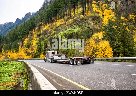 Klassischer, beigefarbener großer Lkw-Auflieger mit verlängerter Fahrerkabine für die Ruhestellung des LKW-Fahrers für den Transport eines leeren Treppenhauses mit Auflieger auf Autobahnen Stockfoto