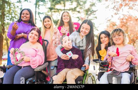 Internationaler Frauentag Inspiire Inspired Inclusion multiethnische Gruppen lieben Herz mit Händen. Rollstuhl Stockfoto