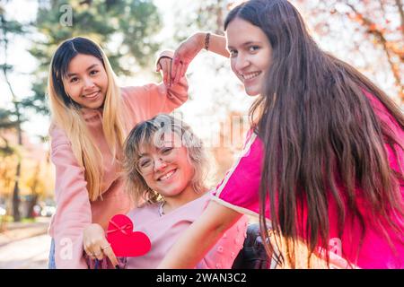 Inspirieren Sie die Inklusion feministischer Gleichheit und Vielfalt Herzenssymbol. Gruppe mit zerebraler Parese Stockfoto