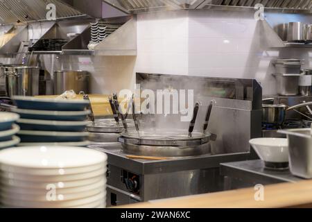 Die belebte Küche eines Ramen-Restaurants, in dem Brühe zu kunstvoll zubereiteten Nudeln gedampft werden, verkörpert die kulinarische Meisterschaft und Hingabe an die Autorität Stockfoto