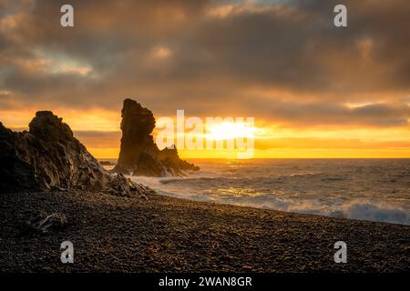 Sonnenuntergang über den vulkanischen Lavaformationen des Djupalonssandur Strandes, Island Stockfoto