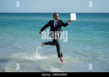 Sommergeschäft. Freiberufler laufen am Sommerstrand. Geschäftsmann im Taucheranzug, Sprung ins Meerwasser. Verrückter Geschäftsurlaub im Sommer. Ein lustiger Geschäftsmann Stockfoto