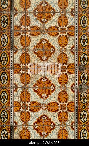 Traditionelle portugiesische Keramikfliesen an der Fassade eines Gebäudes in Orange, Braun und weiß Stockfoto