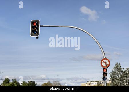 Eine gekrümmte Stange mit einer roten Ampel und einem Schild ohne Linksabbiegel Stockfoto