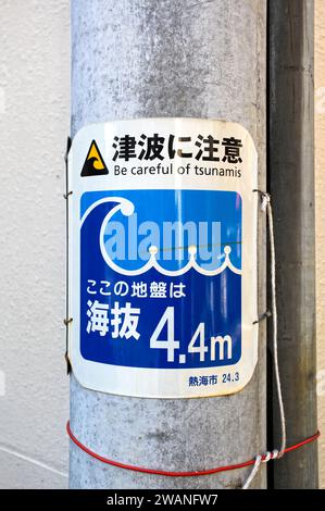 Tsunami-Warnschild und Höhenschild auf der Straßenpost in Atam, Japan. Stockfoto