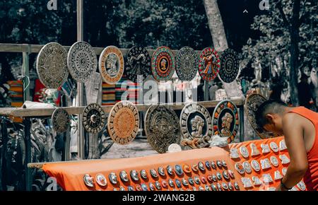 Marktstände, an denen Holzmasken und andere lokale Souvenirs und Kunsthandwerk an Touristen verkauft werden, die Chichen Itza Maya-Ruinen in Mexic besuchen Stockfoto